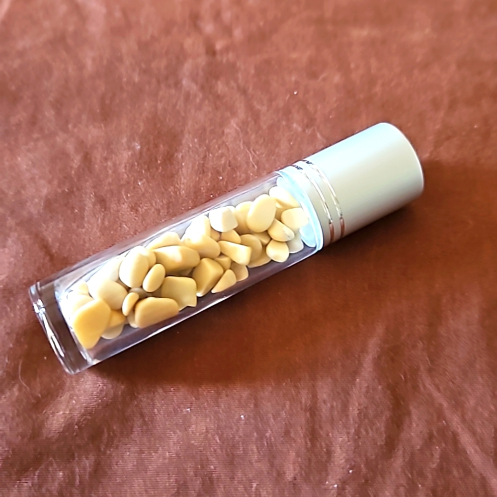 Empty glass roll on bottle with Yellow calcite chips inside